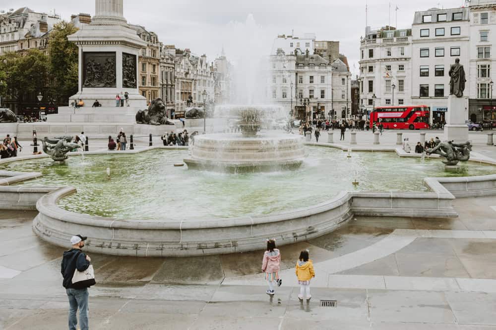 Kids enjoying the Trafalgar Square fountain as part of the 2 day London itinerary with kids